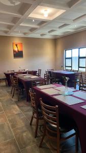 a dining room with tables and chairs in a restaurant at Solomon Guest House in Maseru