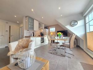a kitchen and living room with a table and chairs at Ferienwohnung Meerglück in Norden