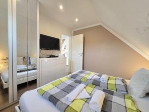a bedroom with a large bed and a tv at Ferienwohnung Meerglück in Norden