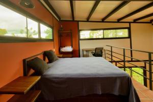 a bedroom with a bed in a room with windows at Casa Papaya in Los Chacareños
