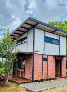 a brick house with a black roof at Casa Papaya in Los Chacareños