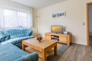 a living room with a blue couch and a television at Ferienwohnung Edda in Klütz