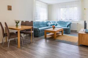a living room with a blue couch and a table at Ferienwohnung Edda in Klütz
