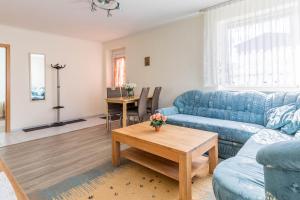 a living room with a blue couch and a table at Ferienwohnung Edda in Klütz +9 photos