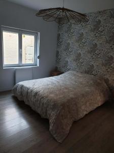 a bedroom with a large bed and a window at Le nid des Huttes in Gravelines +8 photos