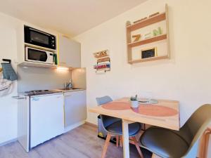 a small kitchen with a small table and a small refrigerator at Appartement Lélex - classé meublé de tourisme 2 étoiles - 4 personnes - pied des pistes - vue montagne in Mijoux
