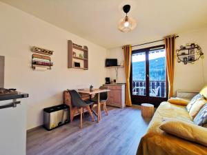 a living room with a desk and a room with a couch at Appartement Lélex - classé meublé de tourisme 2 étoiles - 4 personnes - pied des pistes - vue montagne in Mijoux
