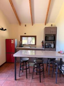 a kitchen with a large table and some stools at Cabañas Altos del Sollipulli in Rumiñano