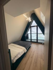 a bedroom with a bed and a large window at Panoramic Nicolas in Borsa