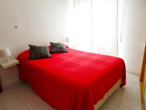a red bed in a room with a window at Dream Apto Old Town in Málaga