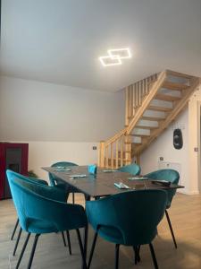 a dining room with a table and blue chairs at Panoramic Nicolas in Borsa