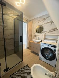 a bathroom with a washing machine and a sink at Panoramic Nicolas in Borsa +23 photos