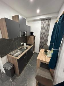 a small kitchen with a sink and a table at Privates Studio mit Parkplatz NAC in Euskirchen