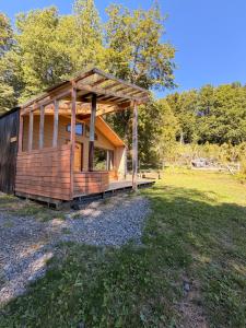 a wooden cabin in a field with trees in the background at Cabañas Altos del Sollipulli in Rumiñano