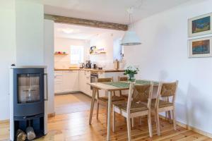 Eine Küche und ein Esszimmer mit Tisch und Kamin in der Unterkunft Ferienhaus Andersson in Klütz