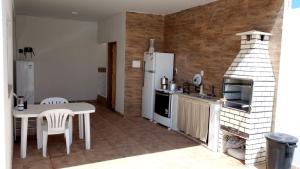 a kitchen with a table and a stove and a refrigerator at Casa temporada aracaju sergipe in Aracaju