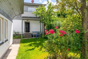 ein Haus mit einem Garten voller rosa Rosen in der Unterkunft Ferienhaus Andersson in Klütz + 35 Fotos