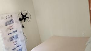 a fan hanging on a wall next to a toilet at Casa temporada aracaju sergipe in Aracaju