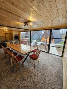 ein großes Esszimmer mit einem Holztisch und Stühlen in der Unterkunft Borlova Frame in Borlova