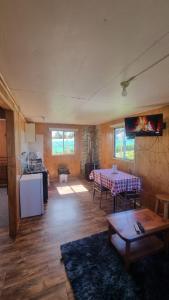 a living room with a table and a kitchen at cabañas cubero in Gualaihue