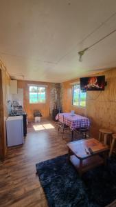 a living room with a table and a kitchen at cabañas cubero in Gualaihue