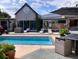 a swimming pool in front of a house at La Ferme de Kérivoas in Audierne