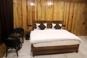 a bedroom with a bed with wooden walls and a table at Tiger Woods in Jamania