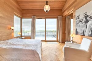 a bedroom with a white bed and a large window at IDAHO - Hoog in Süderstapel