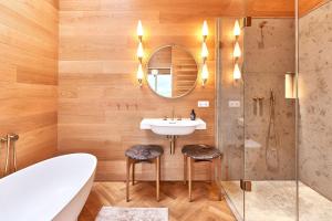 a bathroom with a sink and a tub and a mirror at IDAHO - Hoog in Süderstapel