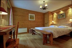 een slaapkamer met een bed en een houten muur bij Juliette in Verbier