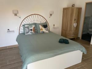 a bedroom with a large bed with two shoes on it at L annexe chambre indépendante avec entrée privée in Fouras