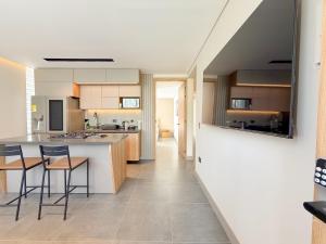 een keuken met een aanrecht en stoelen in een kamer bij Apartamento de lujo a 3 minutos del Aeropuerto JMC 101 in Rionegro