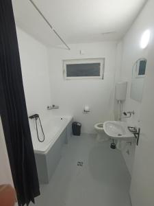a white bathroom with a tub and a sink at MiYo STAY in Žitkovac