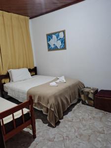 a room with two beds and a picture on the wall at Hostel Palhoça in Palhoça
