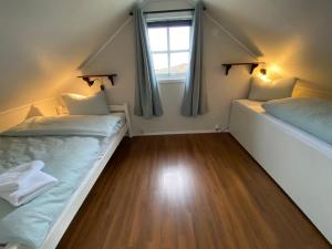 two beds in a small room with a window at Offersøy Feriesenter in Offersøy