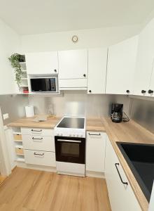 a kitchen with white cabinets and a stove top oven at Kodikas kerrostaloyksiö in Jalasjärvi
