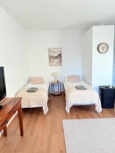 a room with two beds and a tv in it at Kodikas kerrostaloyksiö in Jalasjärvi
