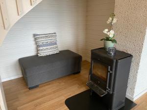 a living room with a couch and a stove at Offersøy Feriesenter in Offersøy