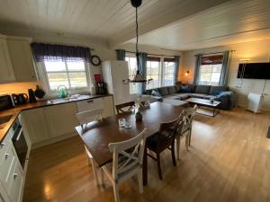 a kitchen and living room with a table and chairs at Offersøy Feriesenter in Offersøy