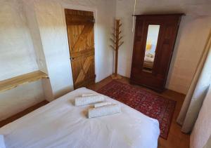 a bedroom with a white bed with two pillows on it at Fisherman's Cottages at Blombosch Game Farm in Yzerfontein