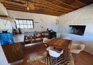 a kitchen with a table and chairs in a room at Fisherman's Cottages at Blombosch Game Farm in Yzerfontein