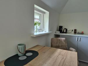 a kitchen with a wooden table with a vase on it at Dalerheugte Drenthe B&B Comfort 5 met eigen badkamer en ontbijt à la carte op de kamer in Dalerveen
