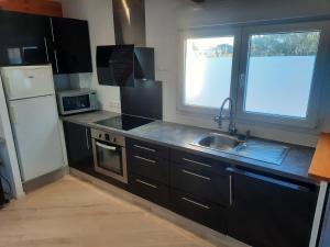 a small kitchen with a sink and a refrigerator at L'Abri Côtier 2 in Les Sables-d'Olonne