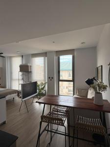 a living room with a table and a television at Demetrio By Alma Suites in Valencia