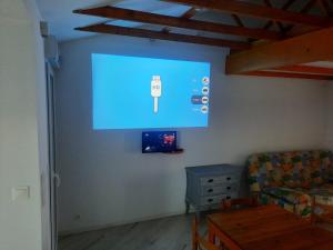 a living room with a large screen on the wall at L'Abri Côtier 2 in Les Sables-d'Olonne