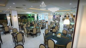 a restaurant with tables and chairs in a room at Al-Assadi Hotel in Erbil