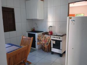 a kitchen with a stove and a table and a refrigerator at Flats Mundos Golfinhos in Pipa