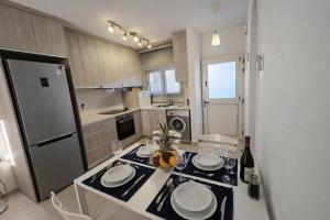 a kitchen with a table with plates on it at Seaside Escape Apartment in Larnaca +39 photos
