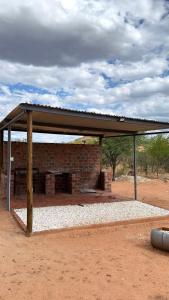 a brick building with a roof on top of it at Okatjongoro Campsite in Gkamboro Settlement