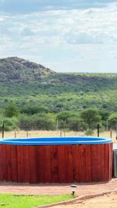 a large swimming pool in the middle of a field at Okatjongoro Campsite in Gkamboro Settlement